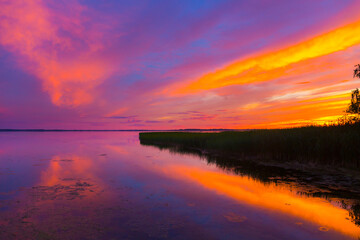 Beautiful colorful sunset over the lake summer landscape.