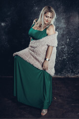 Attractive plump woman in green dress studio portrait.