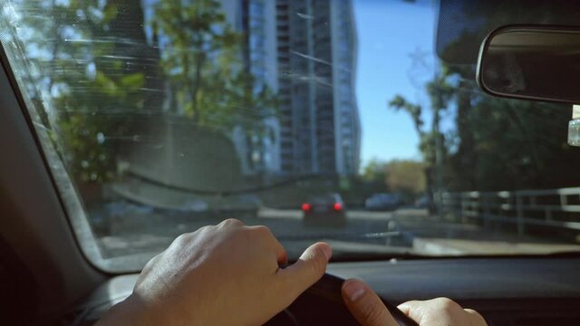 First-person View Of A Man Driving A Car Moving Around The City. Sun Glare.