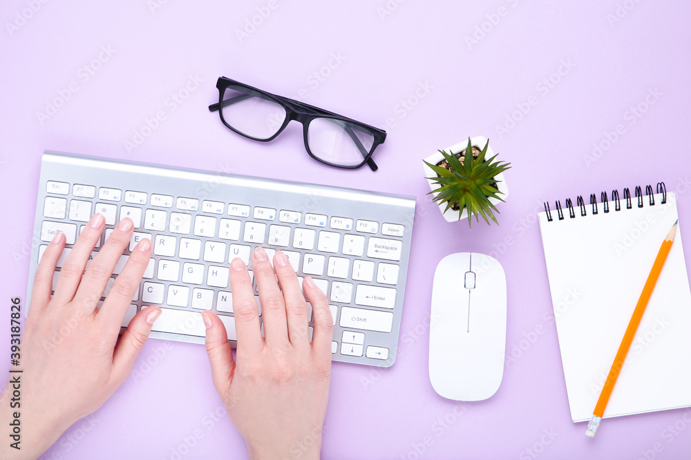 Poster female hands typing on computer keyboard with mouse and notepad
