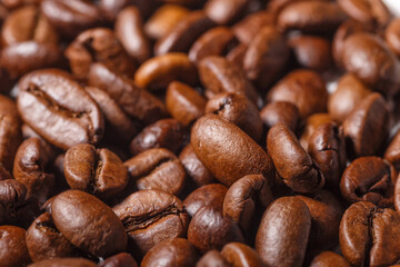 Freshly roasted coffee beans background.Dark roasted coffee beans with scoop on wooden background.