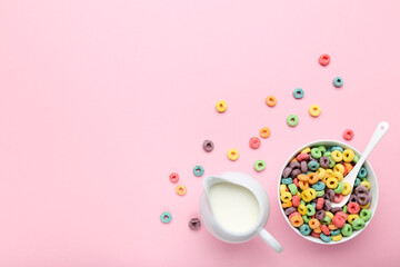 Colorful corn rings with milk in jar and spoon on pink background