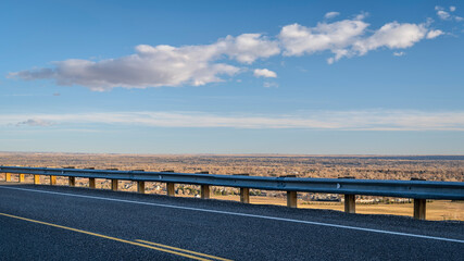 highway at Colorado foothills with a view of plains and city of Fort Collins, fall scenery