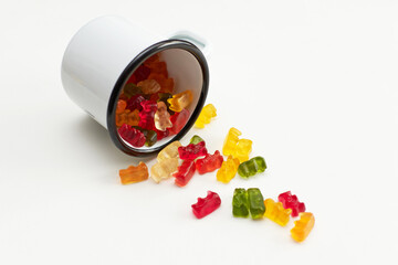 Closeup shot of colorful gummy bears falling out of a cup