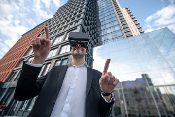 Man in black suit wearing vr glasses and looking entertained