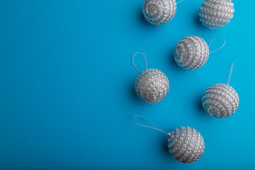 Christmas or New Year composition. Decorations, silver balls, on a blue background. Top view, copy space.
