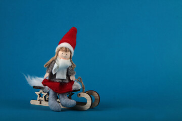 a girl on the sledge isolated on blue background. Winter concept