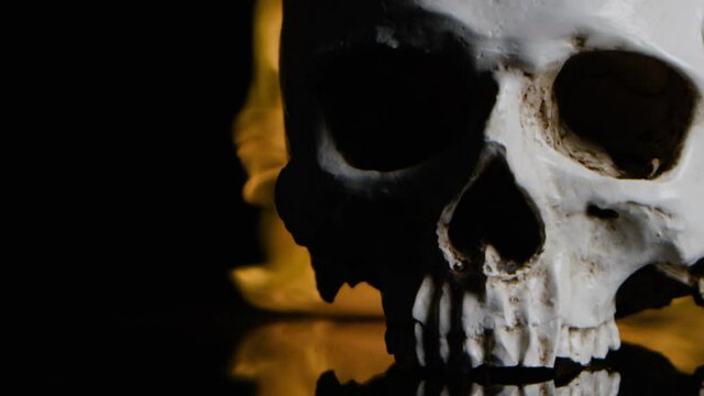 A skull burning in extreme slow motion - imagery denoting the horrors of war, and the christian imagery of sin and hell
