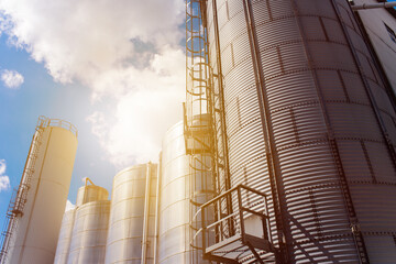 Rows of aluminum tanks against the sky. Modern elevator. © salomonus_