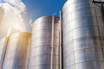 Rows of aluminum tanks against the sky. Modern elevator.