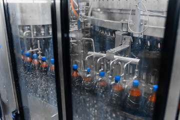 Automatic bottle washer on the beer filling line. Bottle washing process after capping