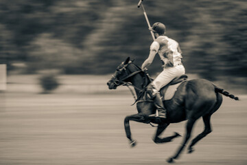Players riding polo ponies in a polo match at Kirtlington Park, Oxfordshire.