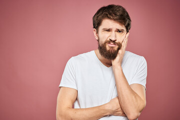 Fototapeta premium emotional man white t shirt sad facial expression pink background
