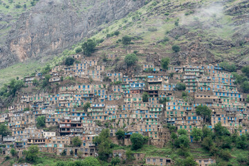 Stepped hillside village with tightly packed traditional houses clinging to rocky mountain slopes...
