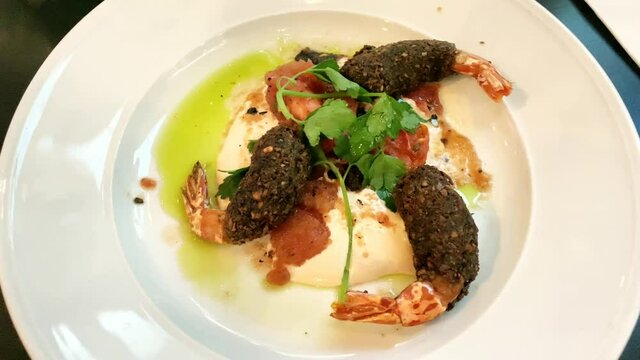Food appetiser plates for party. a snack in an Israeli restaurant. Shrimps in falafel on a plate with hummus decorated with a sprig of parsley. 4K