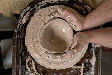 close-up of a Potter's hand sculpts a pot pitcher of clay on a Potter's wheel