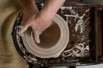 Fototapeta premium close-up of a Potter's hand sculpts a pot pitcher of clay on a Potter's wheel