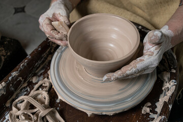 close-up of a Potter's hand sculpts a pot pitcher of clay on a Potter's wheel