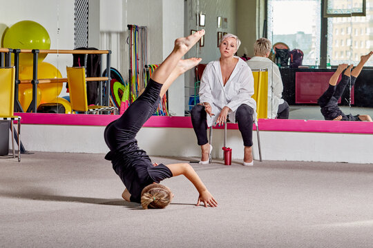 A Young Man Performs Tricks Under The Supervision Of A Teacher. Sports Lifestyle And Body Flexibility. A Woman Speaks To A Student.