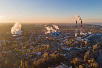 Aerial view of cityscape with industrial enterprises and emission of harmful smoke from the...