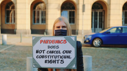 Protest walk declaring that pandemic does not cancel human constitutional rights. Woman in...