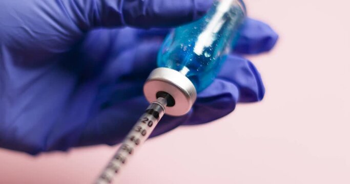 Nurse hands in blue gloves holding vaccine needle syringe hypodermic injection dose for prevention immune treatment illness virus disease