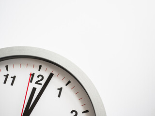 Fototapeta na wymiar Close up of a ticking clock on white background, pointing a few minutes past midnight, copyspace
