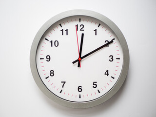 Close up of a ticking clock on white background, pointing a few minutes past midnight, copyspace