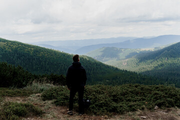Fototapeta premium Hiking and climbing up to the top of the mountain. Men tourist is travelling and standing at the root of the mountain and watching to the peak.