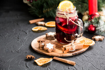 Christmas hot mulled wine with cinnamon cardamom and anise. Dark vintage dirty background. Creative atmospheric decoration