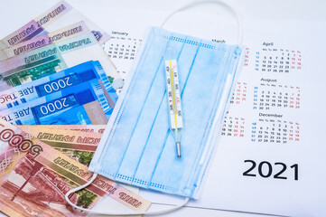Calendar and face mask. Thermometer and autumn leaves on a white background.