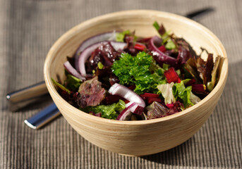 Close-up of spring salad in wooden bowl