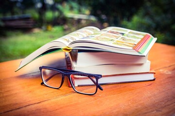 Conjunto de libros de ciencia en una mesa y con unos anteojos 