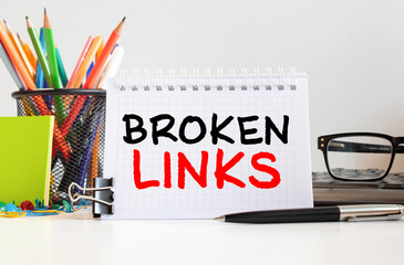 Broken links seo - business concept text on a white background with a hourglass and an open book