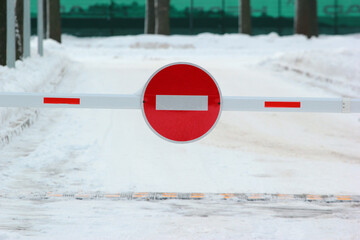 Barrier with no entry sign on snowy road