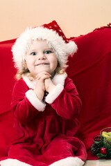 little girl dressed look like miss Santa earnestly beseech that Santa Claus bring her present in Christmas