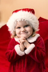 little girl dressed look like miss Santa earnestly beseech that Santa Claus bring her present in Christmas
