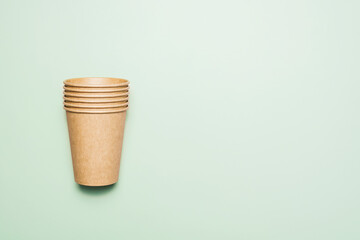 Paper disposable coffee cups on a green background.