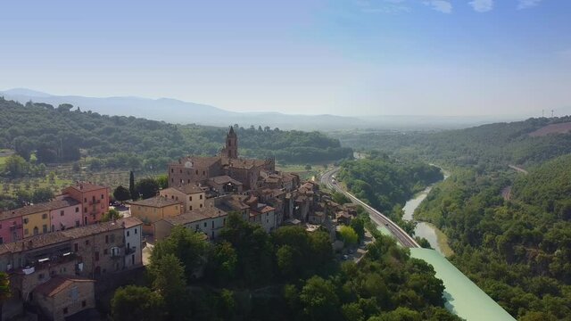 Drone shot over old beautiful old Catholic church and villas in Tuscany, Italy. Big road and river are on the right. Old beautiful Italian city.