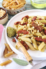 Whole wheat penne pasta with pesto sauce and sun dried tomatoes, pine nut dressing