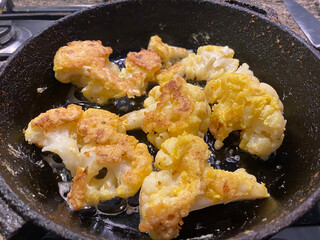 golden fried cauliflower in a skillet