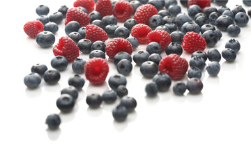 Raspberries and blueberries on white background