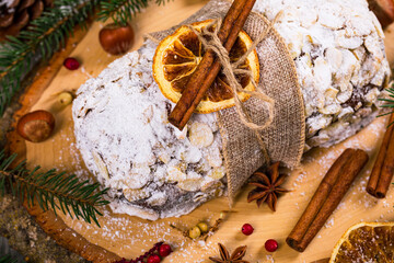 Christmas Holiday Background. Stollen, German Christmas Cake with Dried Fruits and Sliced Almonds Nuts. Selective focus.  
