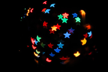 Abstract of colorful background. star shaped bokeh light. shimmering blur spot lights on multicolored holiday background