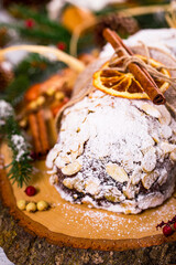 Christmas Holiday Background. Stollen, German Christmas Cake with Dried Fruits and Sliced Almonds Nuts. Selective focus.  