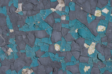Peeling paint on the wall. Old concrete wall with cracked flaking paint. Weathered rough painted surface with patterns of cracks and peeling. Grunge texture for background and design. High resolution.