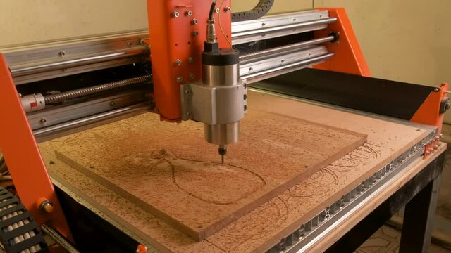 Accelerated shooting. A wooden cnc machine drills a cutting Board. Automated mechanism. Movement of the drill along the specified route on the computer