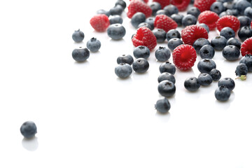 Raspberries and blueberries on white background