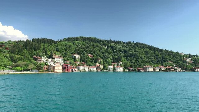 Footage of historical mansions at upscale neighborhood called "Kandilli" in Istanbul. It is a beautiful Bosphorus scene in a sunny summer day. Camera moves forward.