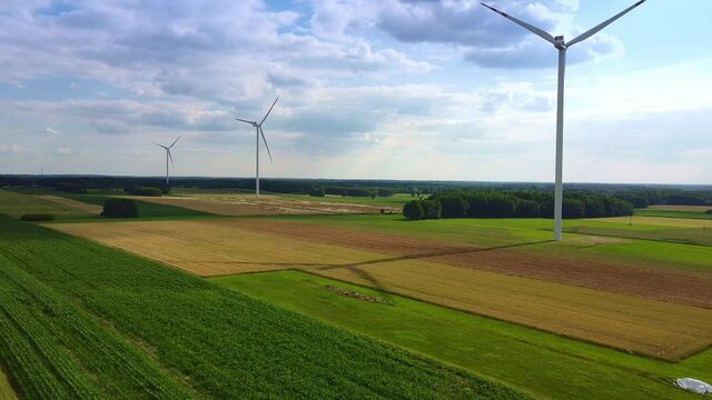 Aerial view of line of wind energy turbines in summer.